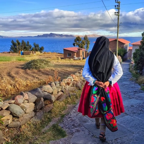 Local person in traditional costume walking on Amantani Island | Ultimate Trekking