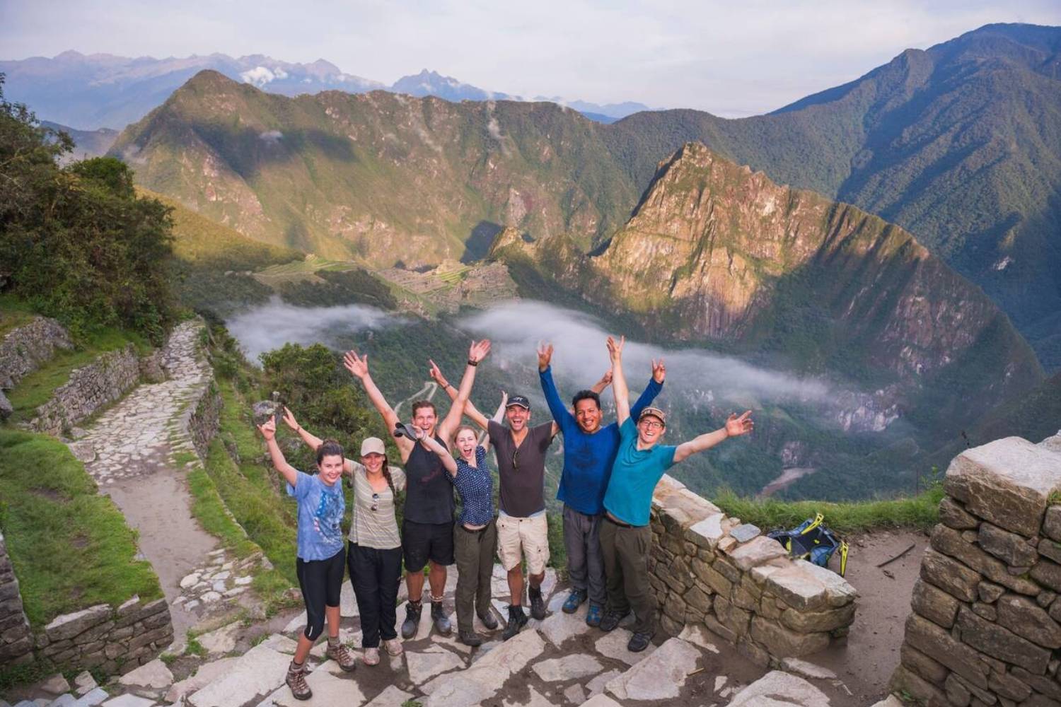 Group of tourists celebrating at the Sun Gate Machu Picchu | Ultimate Trekking