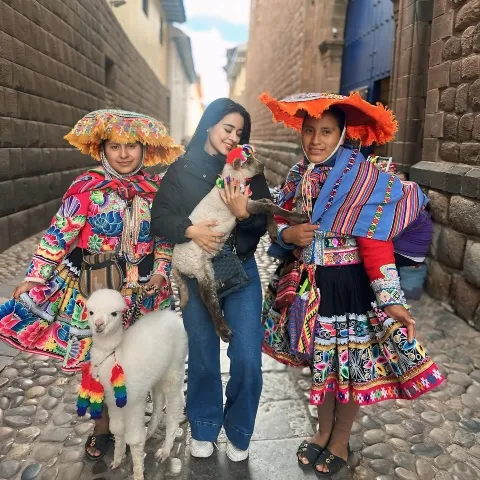 Photo of tourist taking a picture with llamas | Ultimate Trekking