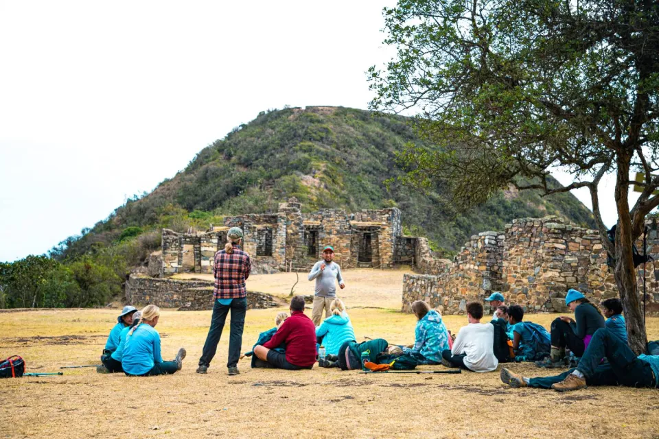 Group of tourists receiving an explanatory talk from the tour guide in Choquequirao | Ultimate Trekking