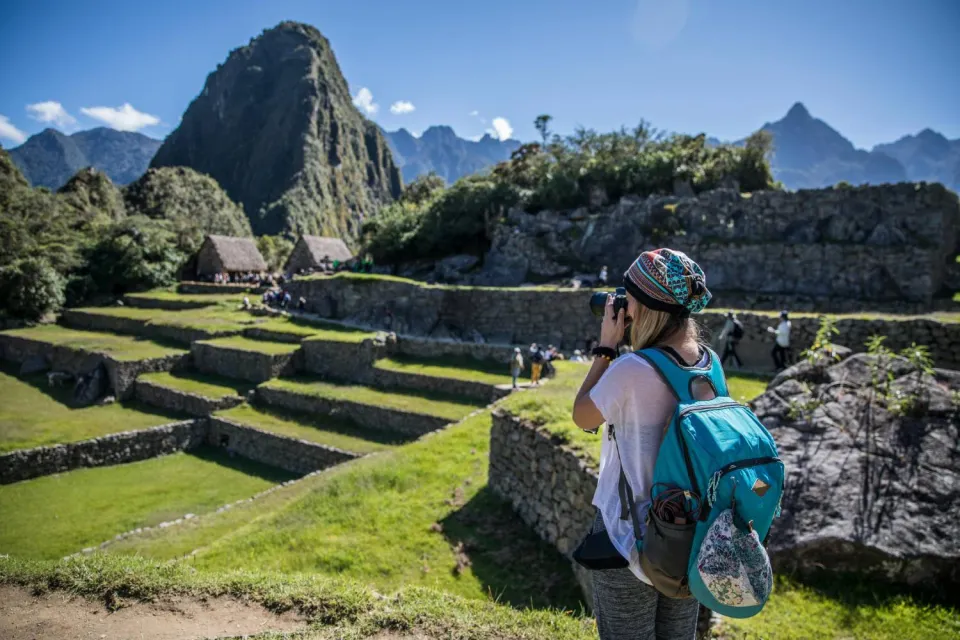 Tourist taking photos in Machu Picchu | Ultimate Trekking