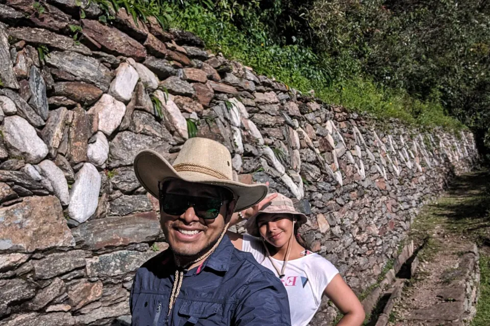 Tourist taking photo in one of the agricultural terraces of Choquequirao llamas | Ultimate Trekking