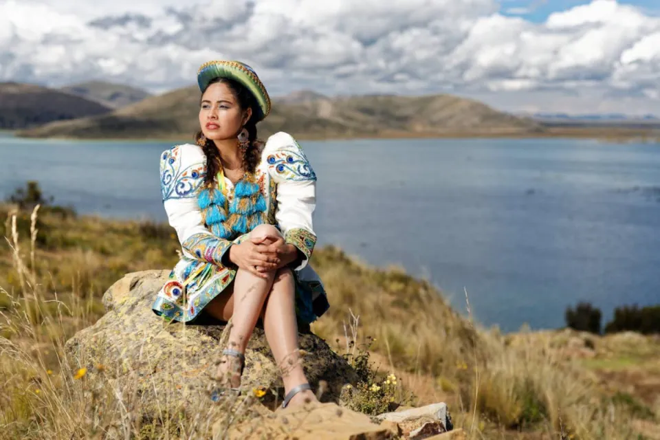 Dancer of the Virgin of Candelaria and Lake Titicaca in the background | Ultimate Trekking