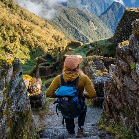 Tourist with his backpack descending the stairs of Sayacmarca on the Inca Trail | Ultimate Trekking