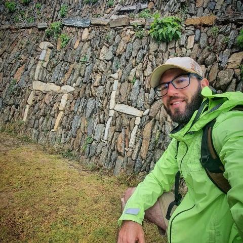 Tourist taking photo with two llama figures in Choquequirao | Ultimate Trekking