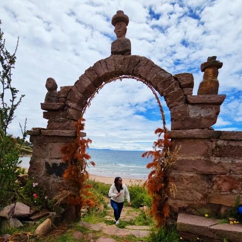 Tourist passing one of the arches of Taquile Island | Ultimate Trekking