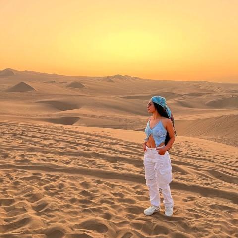Girl enjoying the sunset from the dunes of Huacachina | Ultimate Trekking